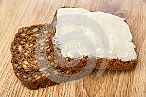 Slice of bread with sunflower seeds, sandwich with butter on table