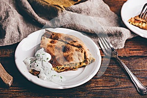 Slice of cabbage pie with sour cream sauce