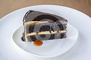 Slice of caramel chocolate cheese cake on white plate