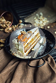 Slice of carrot cake with cream cheese and walnuts. The restaurant or cafe atmosphere. Vintage