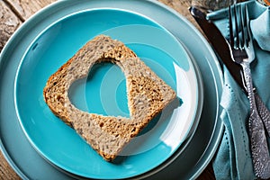 Slice of cereal toast bread with cut out heart shape.
