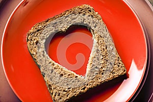 Slice of cereal toast bread with cut out heart shape.