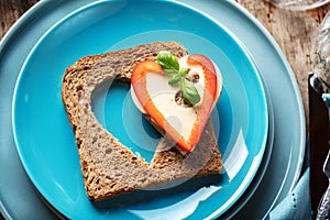 Slice of cereal toast bread with cut out heart shape.