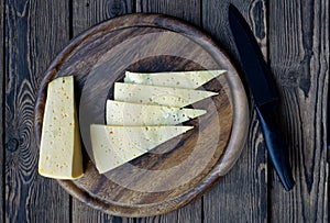 Slice cheese on wooden cutting board