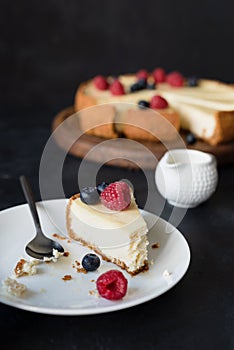 Slice of cheesecake with missing bite on white plate