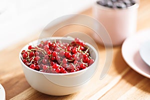 Plate with red currant on thw wooden table photo