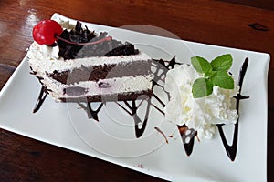Slice of chocolate black forest cake with a cherry