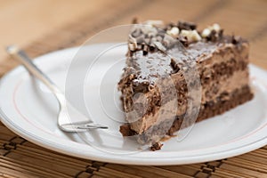 Slice of chocolate cake garnished with nuts