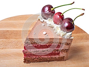 Slice Chocolate caramel cake with cherries on wooden board plate