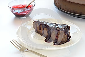 Slice of chocolate cheesecake on white plate