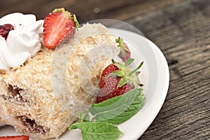 Slice of cream puff cake with strawberry on wooden table. Select