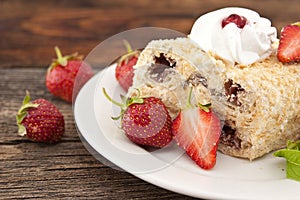 Slice of cream puff cake with strawberry on wooden table. Select