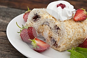 Slice of cream puff cake with strawberry on wooden table