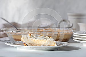 A slice of custard pie topped with merengue, ready for eating.
