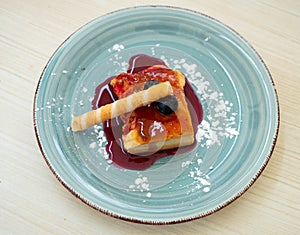 Slice of delicious cake with cheese mousse with blueberry topping on plate. Spanish dessert tarta de queso con arandano