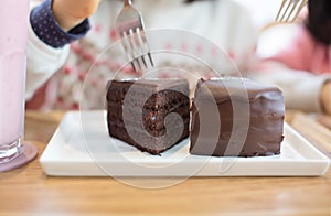 A slice of delicious chocolate cake. Piece of cake on a plate. Sweet food. Sweet dessert. Close up of birthday cake being eaten.