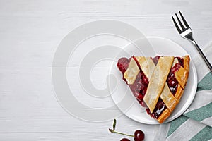 Slice of delicious fresh cherry pie served on white table, flat lay. Space for text