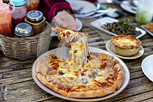 Slice of delicious pizza On a plate on wooden table