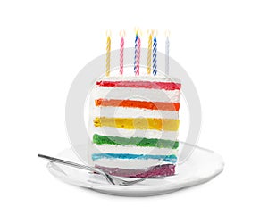 Slice of delicious rainbow cake with candles