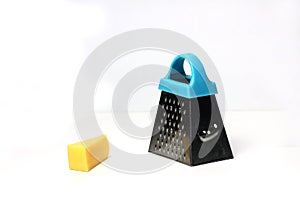 Slice of Edam cheese and fine grater isolated on white background