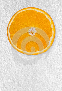 Slice of fresh orange isolated on the white background. Frozen fruits on the snow