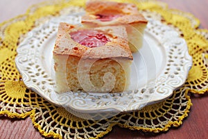 Slice of fresh plums cake on white plate