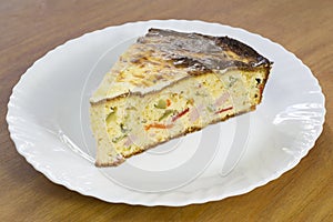 Slice of Freshly Baked Cornbread With Vegetables and Ham on White Plate