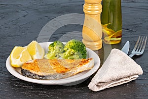 Slice of fried salmon for dinner on the dark table.