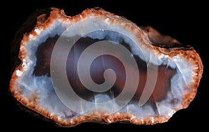 Slice of geode with red and blue chalcedony and red zeolite crystals on the periphery