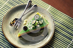 Slice of green lime cheesecake decorated with white chocolate and blueberries