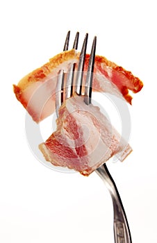 A slice of ham on a steel fork.