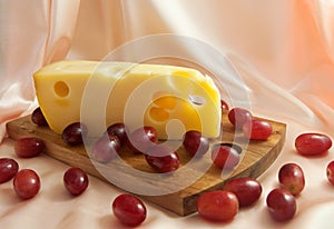 Slice of Jarlsberg Cheese with red grapes