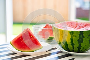 A slice of juicy red watermelon in white plate