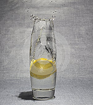 Slice of lemon dropped in glass of water