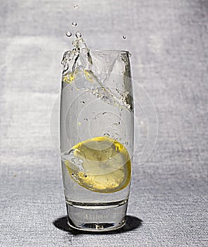 Slice of lemon dropped in glass of water