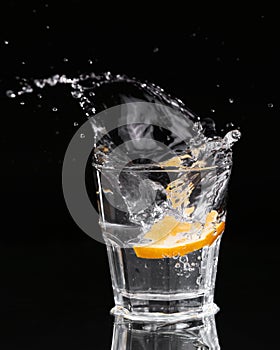 Slice of lemon splashing into a glass of water