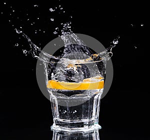 Slice of lemon splashing into a glass of water