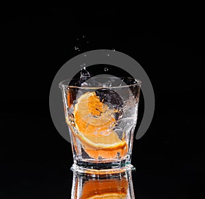 Slice of lemon splashing into a glass of water