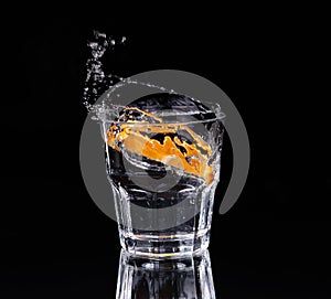 Slice of lemon splashing into a glass of water