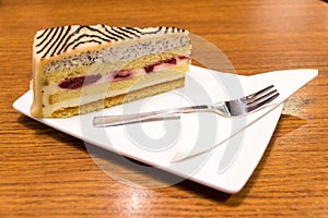 Slice of marzipan cake with tray and fork served in a coffee bar in Vienna, Austria
