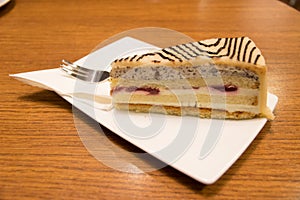 Slice of marzipan cake with tray and fork served in a coffee bar in Vienna, Austria