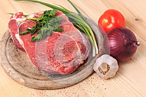 Slice of meat on the cutting board with spices, onion, garlic an