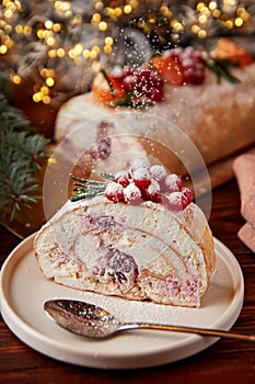 Slice of meringue roll with cherries decorated for Christmas