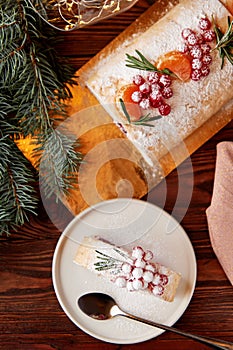 Slice of meringue roll with cherries decorated for Christmas