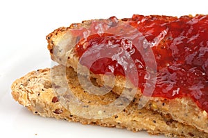 Slice of multi-seed wholegrain bread toasted and buttered with jam.