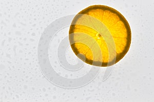 Slice of orange fruit on white background with water drops