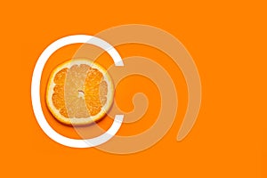 A slice of orange on an orange background with C letter drawed