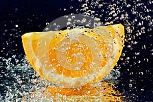 Slice of orange with stopped motion water drops