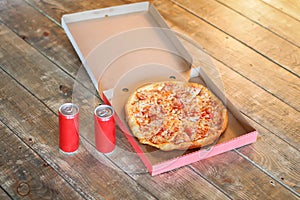 Slice pizza in box and can of soda.