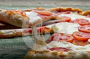 Slice pizza on wood fork. Close-up